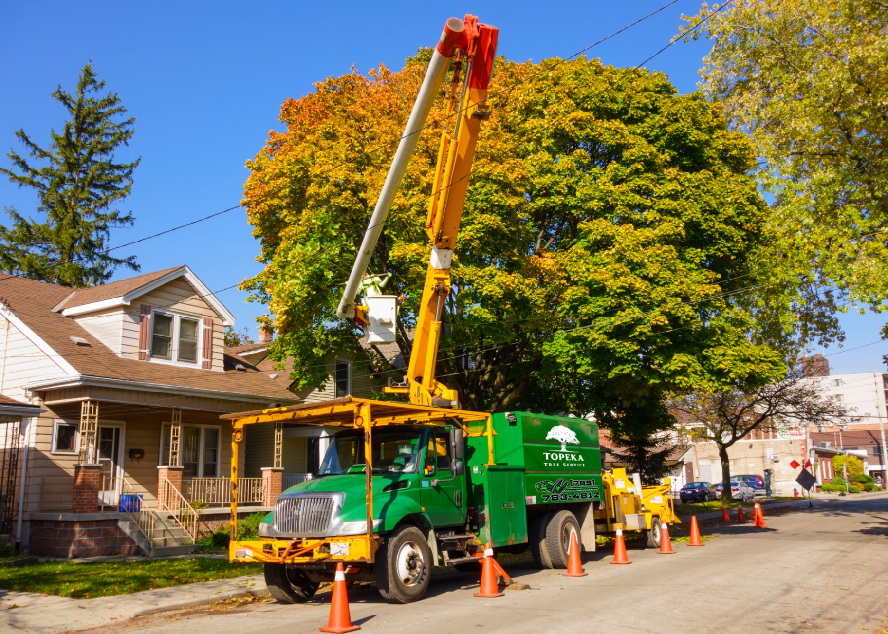 Topeka Tree Service branded bucket truck on job site